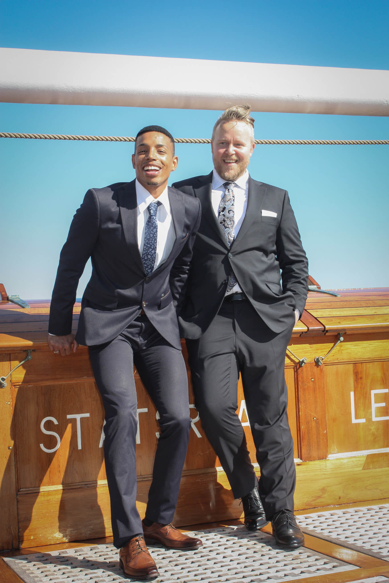 Two men in suits on a tallship.